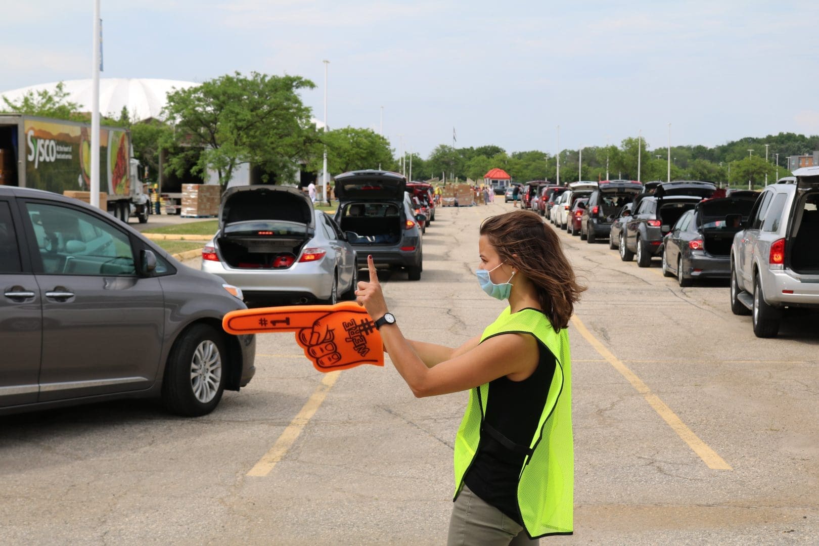 Second harvest staff person directing traffic at a food distribution site