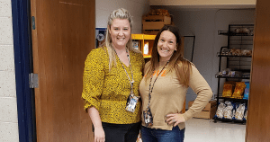 Tara and Erica standing in front of school market in Reedsburg High School