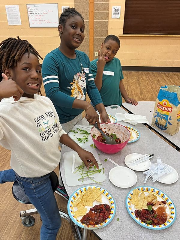 Kids preparing and eating Harvest Snack food.