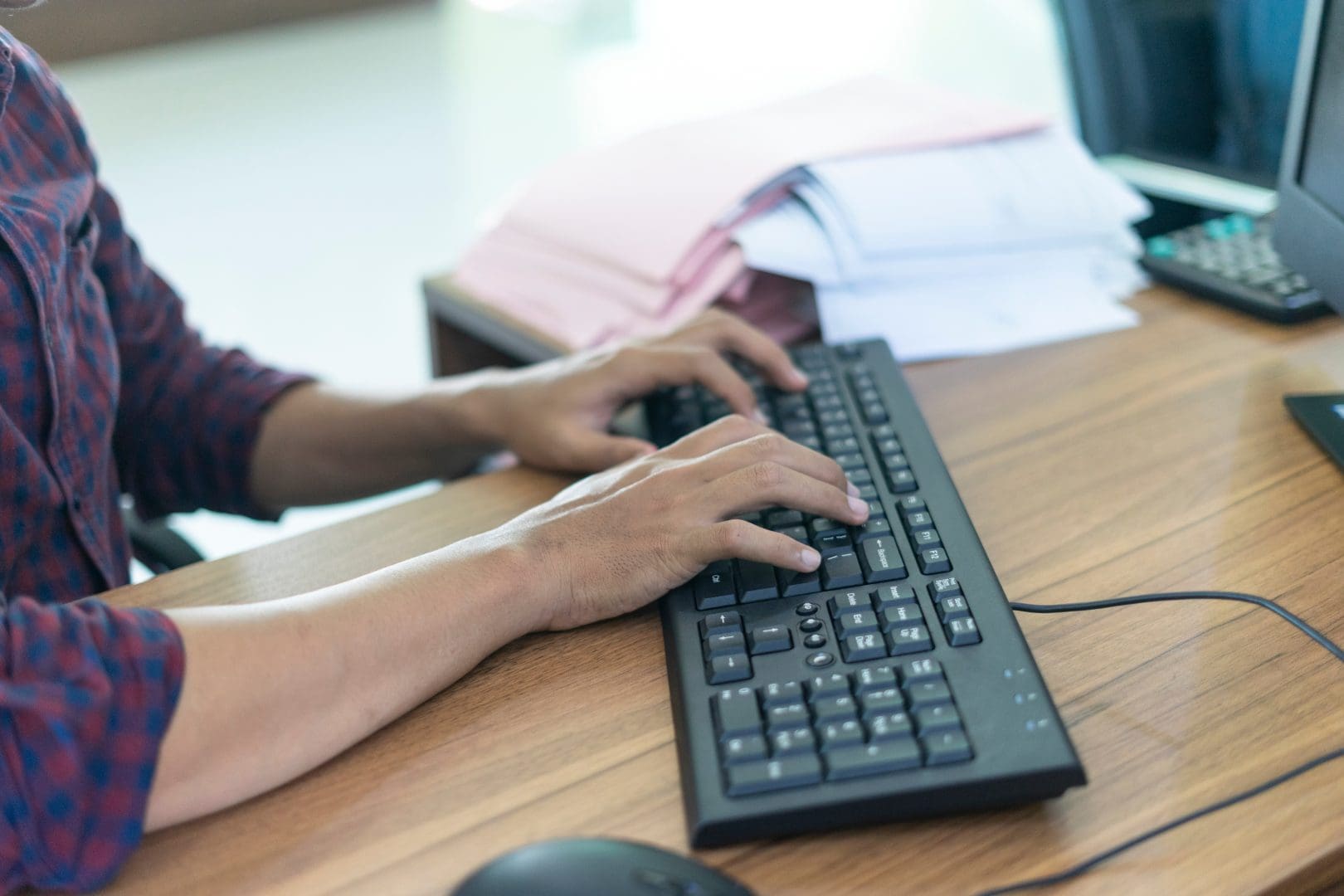 Man WorkingBy UsingAComputer On Wooden Table