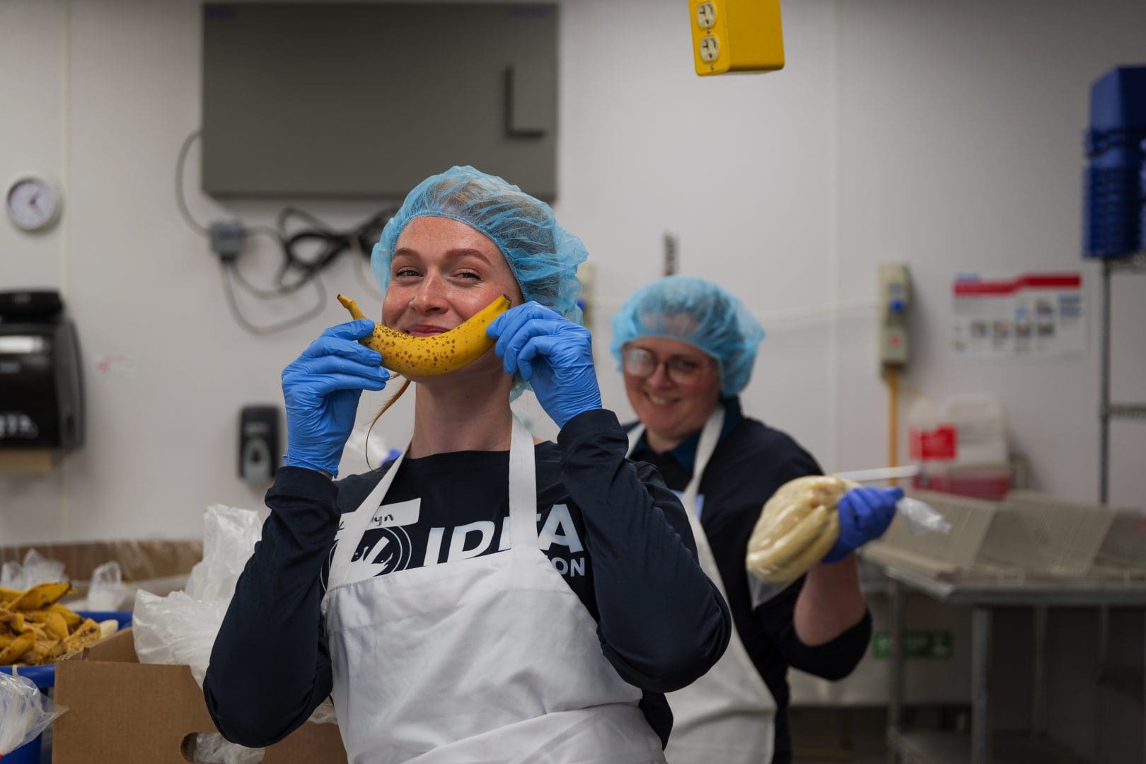 Food rescue team members in hairnets and gloves repacking food